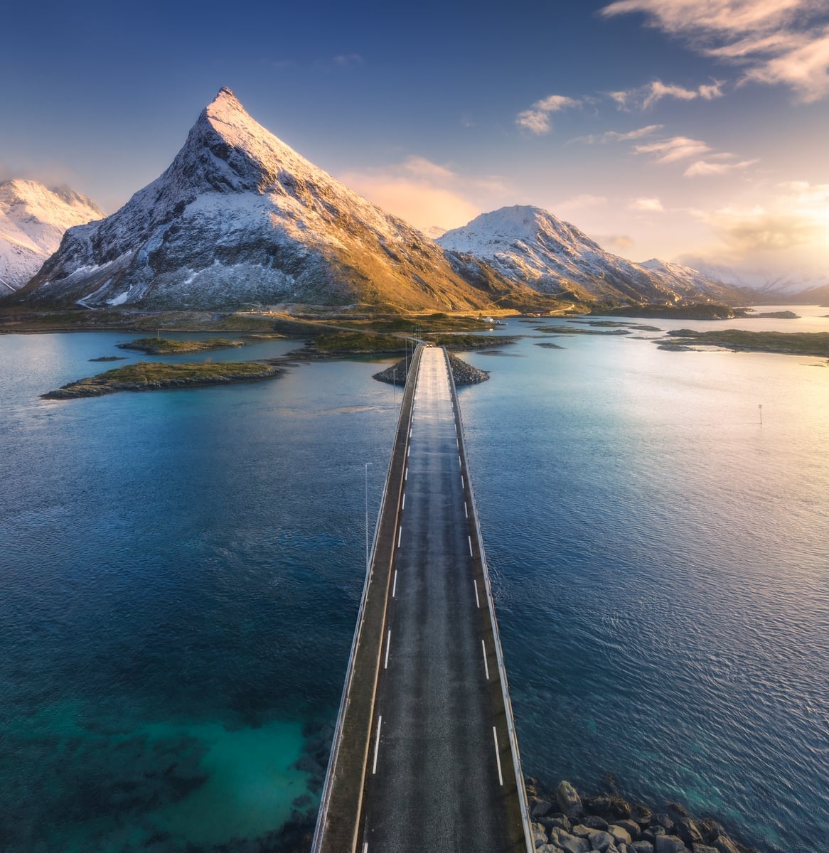 aerial view of bridge over the sea and snowy mount