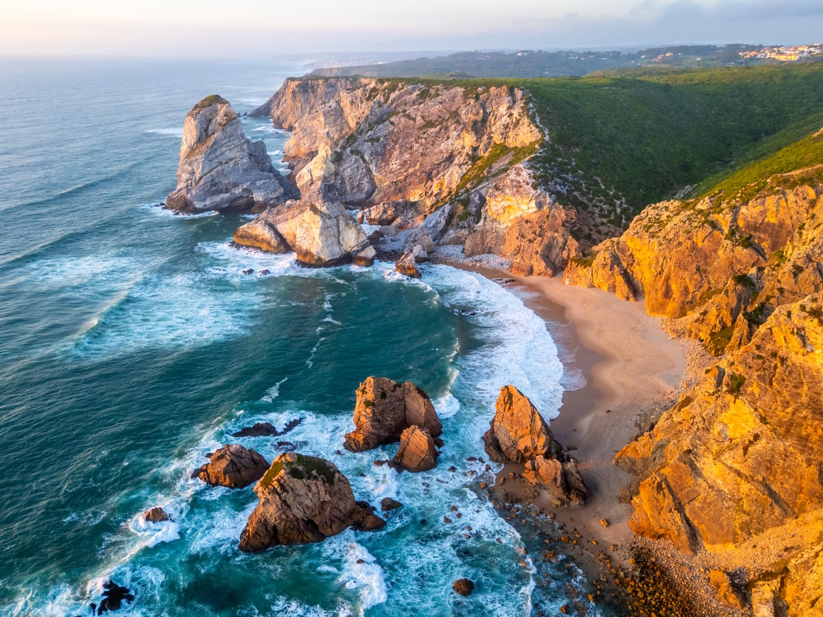 ursa beach cliffs and atlantic ocean waves at sun